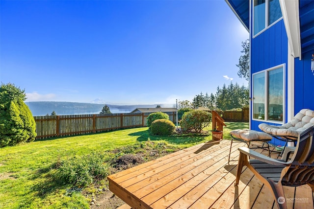 wooden terrace featuring a mountain view and a yard