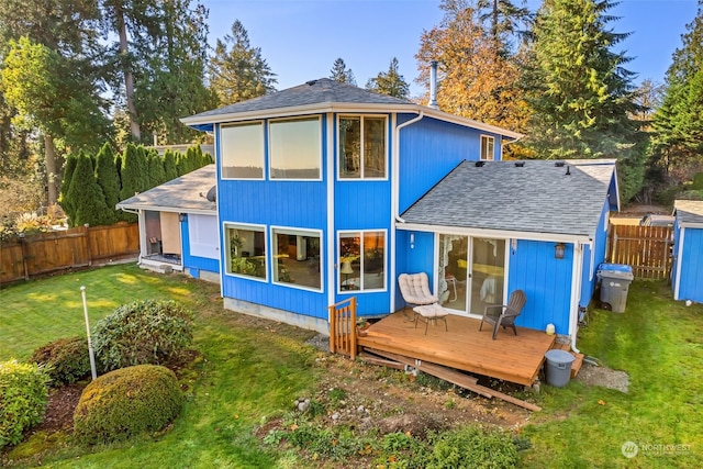 rear view of property featuring a yard and a wooden deck