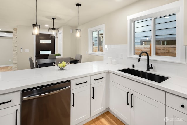 kitchen featuring white cabinetry, light stone countertops, sink, dishwasher, and a wall unit AC