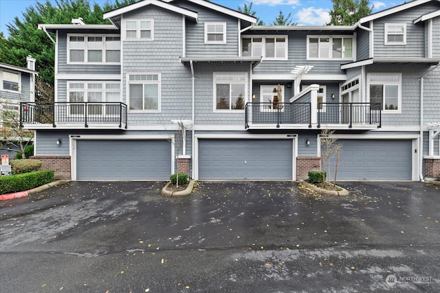 townhome / multi-family property with brick siding, driveway, and an attached garage