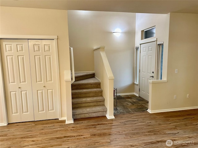 stairs with wood finished floors and baseboards