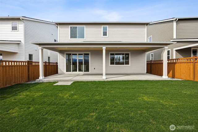 rear view of property featuring a yard, a patio area, and a fenced backyard