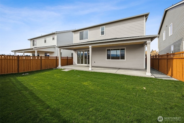 back of property with a yard, a fenced backyard, and a patio area