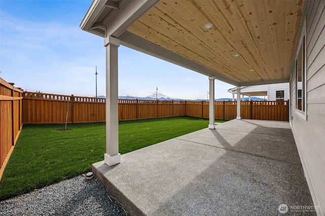 view of patio / terrace featuring a mountain view and a fenced backyard