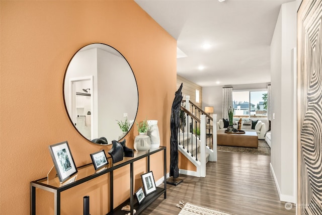 corridor with recessed lighting, dark wood-style flooring, baseboards, and stairs