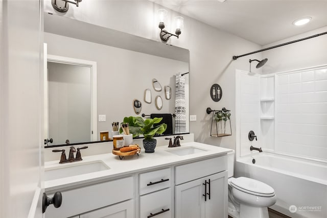 bathroom with double vanity, toilet, a sink, and shower / bathing tub combination