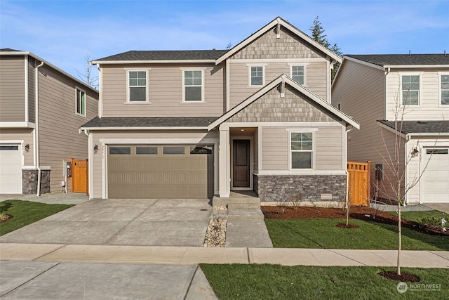 craftsman inspired home with a garage and a front lawn