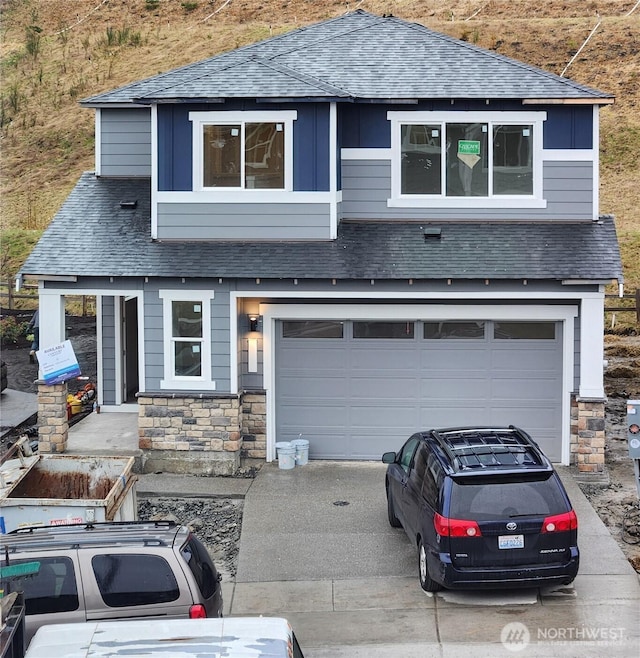 view of front of home featuring a shingled roof, stone siding, driveway, and board and batten siding