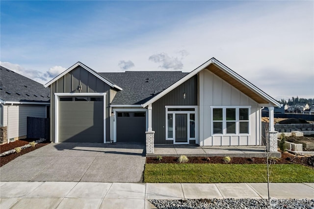 25708 64th Avenue Ct E Unit 4, Graham, WA 98338 - view of front of property with board and batten siding, concrete driveway, a garage, and roof with shingles
