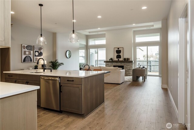 25708 64th Avenue Ct E Unit 4, Graham, WA 98338 - kitchen featuring a sink, dishwasher, light countertops, a stone fireplace, and light wood finished floors