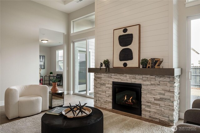 25708 64th Avenue Ct E Unit 4, Graham, WA 98338 - living area featuring wood finished floors, a fireplace, a towering ceiling, and baseboards