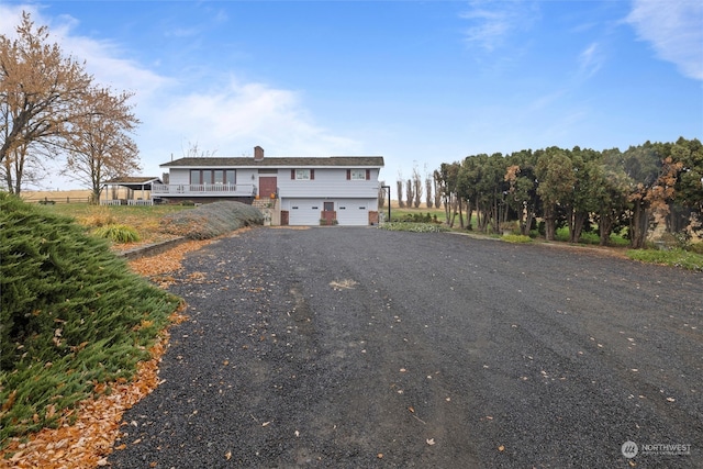 front of property with a garage and a wooden deck
