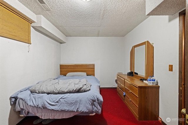 carpeted bedroom featuring a textured ceiling