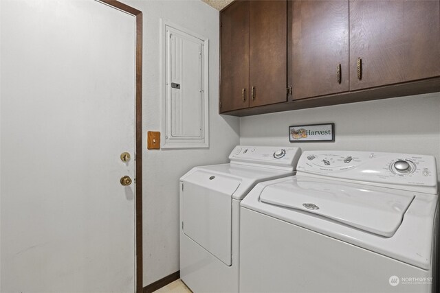 clothes washing area with cabinets, separate washer and dryer, and electric panel
