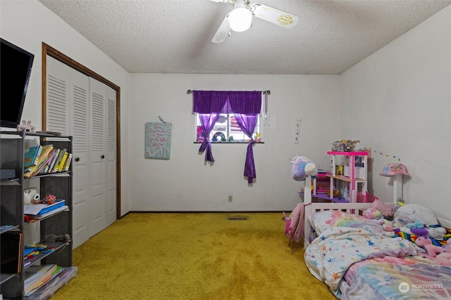 carpeted bedroom with ceiling fan, a closet, and a textured ceiling