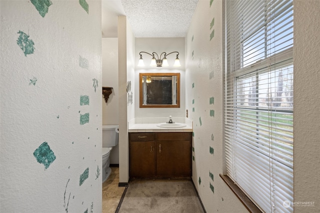 bathroom featuring vanity, toilet, and a textured ceiling