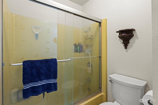 bathroom with toilet and enclosed tub / shower combo