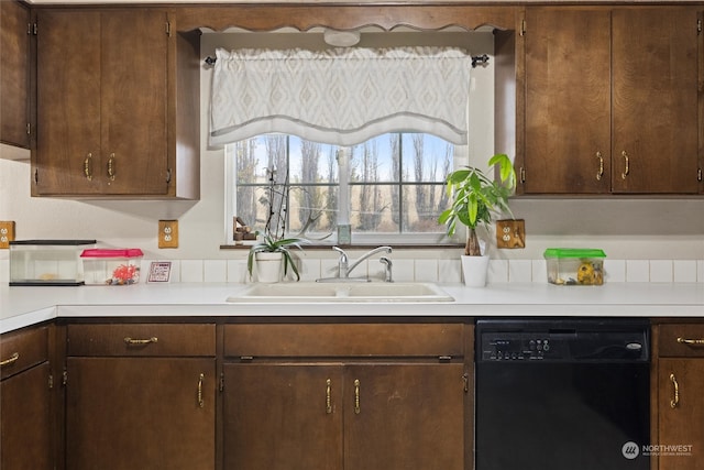 kitchen with dark brown cabinetry, sink, and black dishwasher