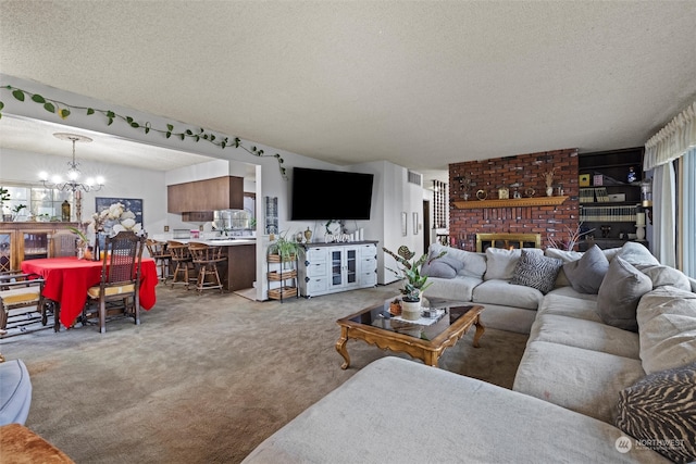 living room with an inviting chandelier, carpet floors, a textured ceiling, and a brick fireplace
