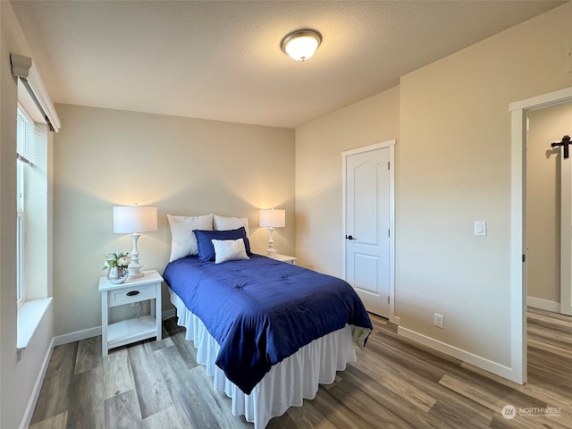 bedroom with wood-type flooring and a textured ceiling