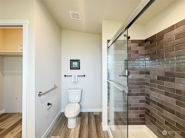 bathroom with hardwood / wood-style flooring, toilet, an enclosed shower, and vaulted ceiling