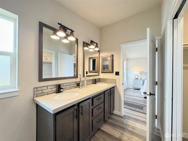 bathroom featuring hardwood / wood-style floors, decorative backsplash, and vanity