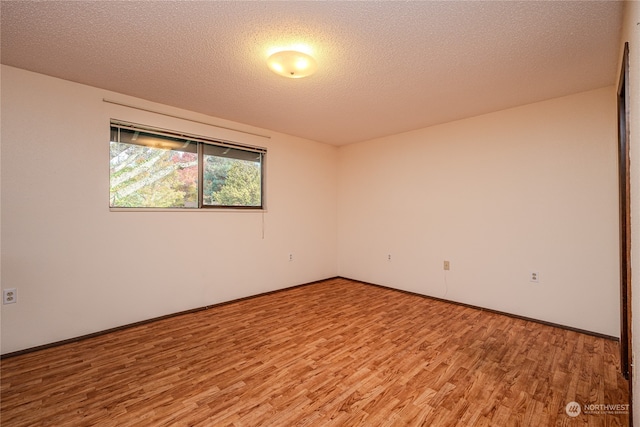 empty room featuring a textured ceiling and hardwood / wood-style flooring