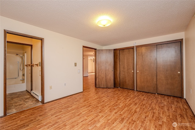 unfurnished bedroom with a textured ceiling and light wood-type flooring