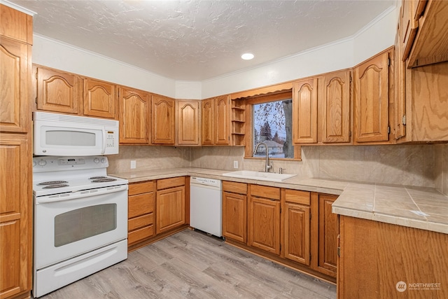 kitchen featuring tile countertops, white appliances, backsplash, sink, and light hardwood / wood-style floors