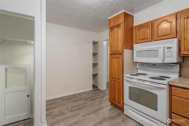 kitchen featuring light wood-type flooring, a textured ceiling, and white appliances