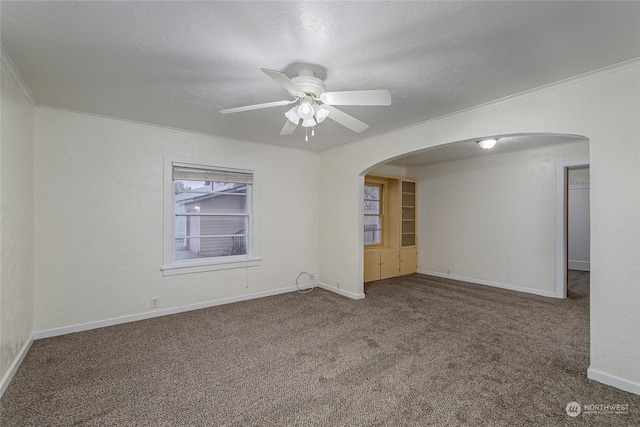 carpeted empty room featuring ceiling fan and crown molding