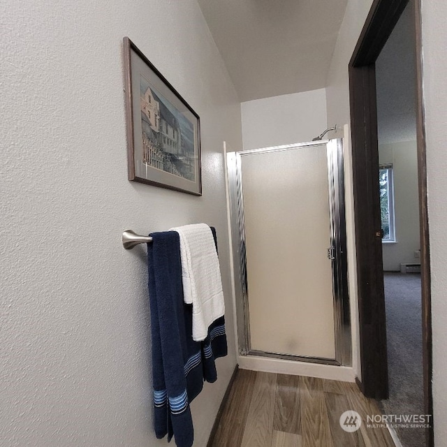 bathroom with wood-type flooring and walk in shower