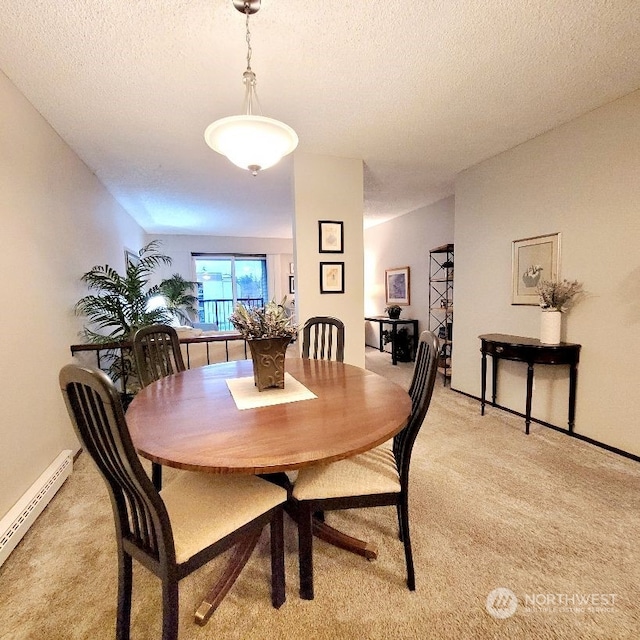 dining room with light carpet, a textured ceiling, and a baseboard radiator