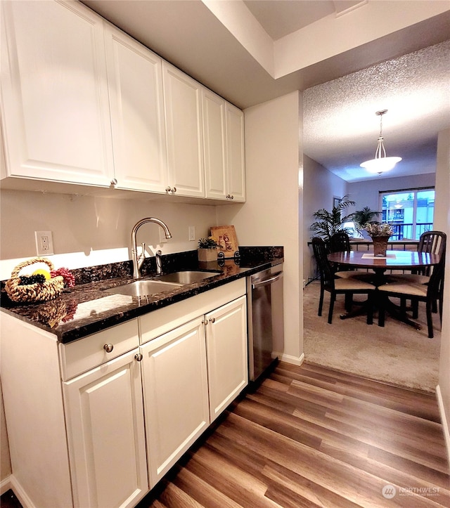 kitchen with white cabinetry, sink, hanging light fixtures, stainless steel dishwasher, and dark hardwood / wood-style floors