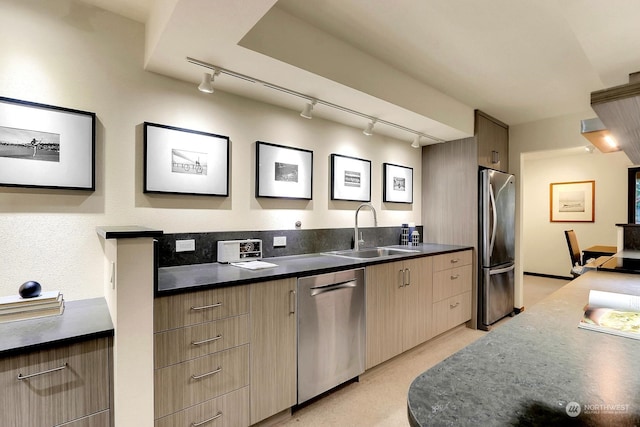 kitchen featuring stainless steel appliances, rail lighting, and sink