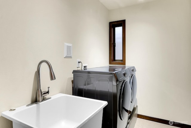 clothes washing area featuring sink and washing machine and dryer