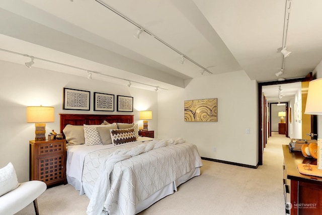 bedroom with track lighting and light carpet