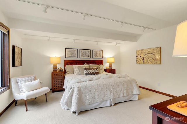 carpeted bedroom featuring rail lighting