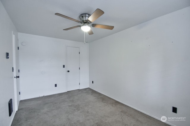 carpeted spare room with ceiling fan