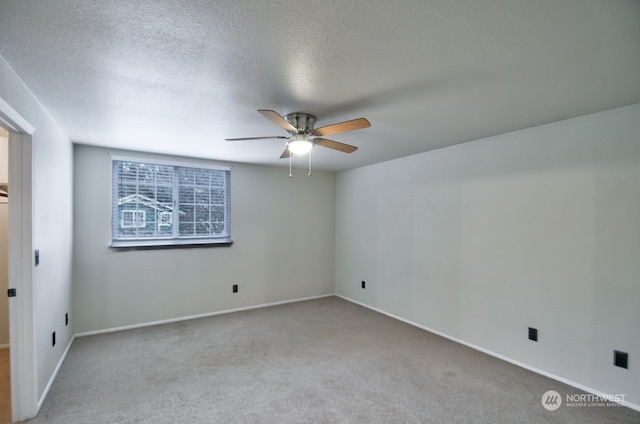 carpeted spare room featuring ceiling fan and a textured ceiling