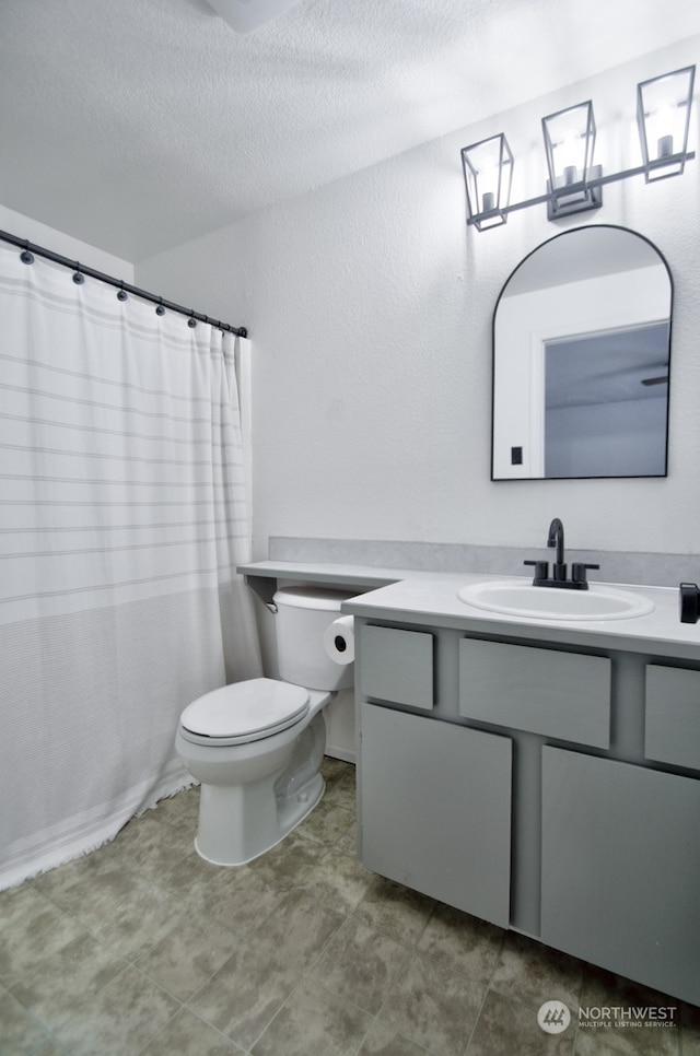 bathroom featuring vanity, toilet, and a textured ceiling