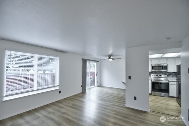 unfurnished living room with ceiling fan and light hardwood / wood-style flooring