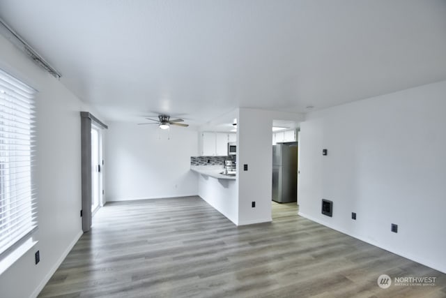 unfurnished living room with ceiling fan and light hardwood / wood-style floors