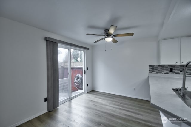 unfurnished dining area with ceiling fan and dark wood-type flooring