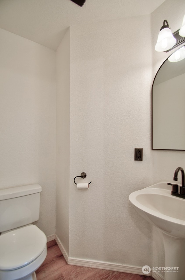 bathroom with hardwood / wood-style flooring, toilet, and sink