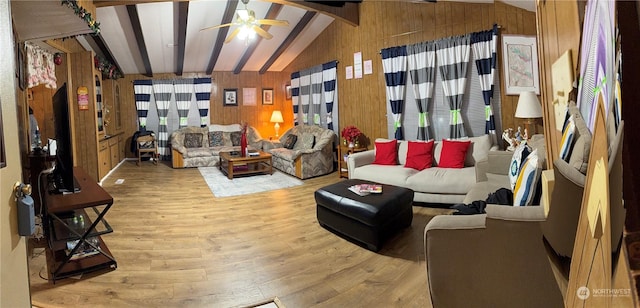 living room with vaulted ceiling with beams, ceiling fan, hardwood / wood-style floors, and wood walls