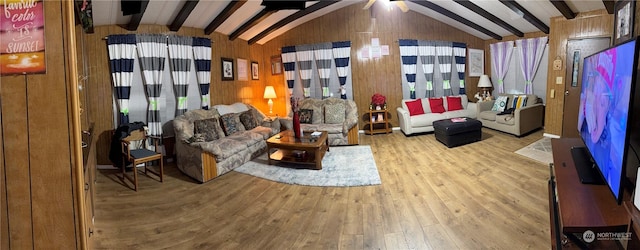 sitting room featuring lofted ceiling with beams, light hardwood / wood-style floors, and wood walls