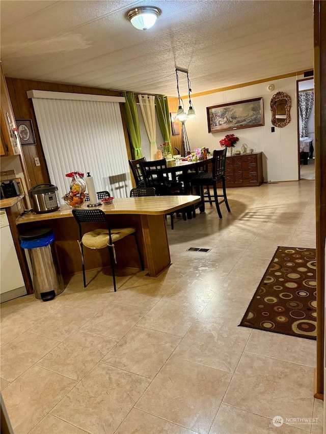 dining room featuring a textured ceiling and light tile patterned flooring