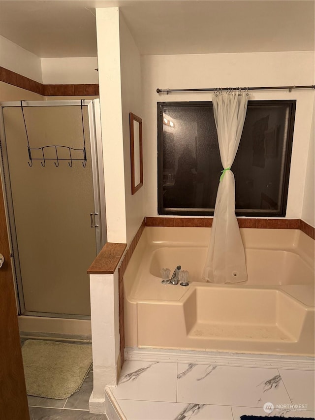 bathroom featuring shower with separate bathtub