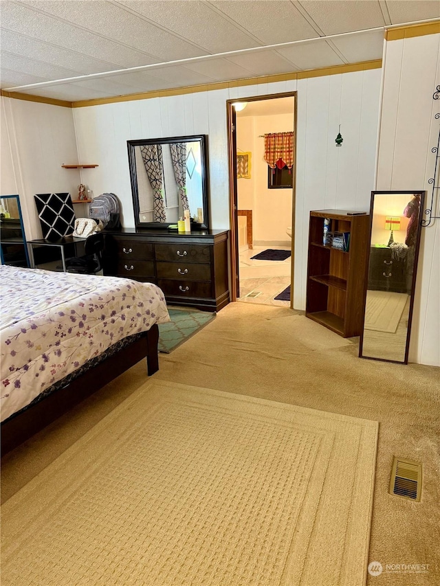 bedroom with light colored carpet and ensuite bathroom